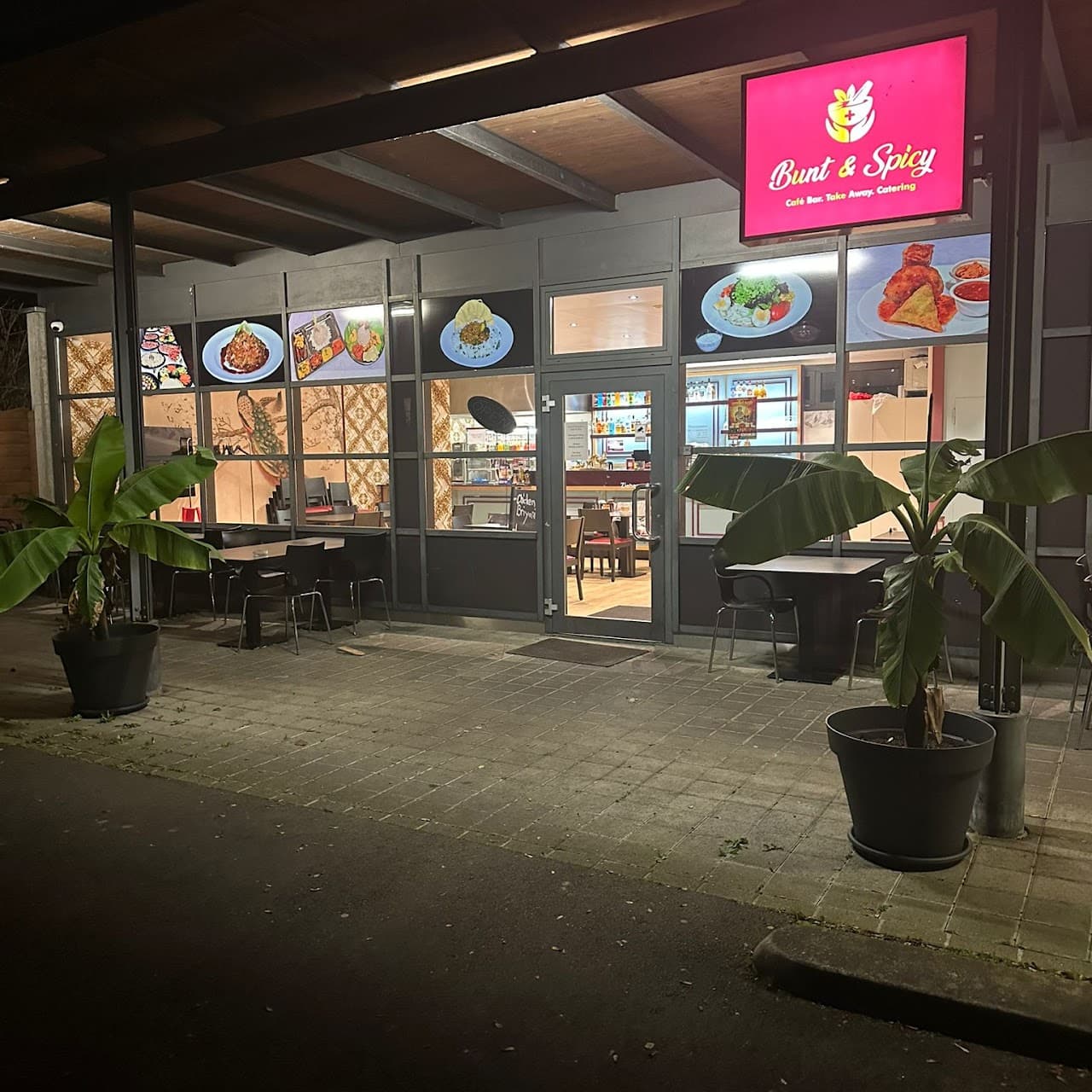 Bunt & Spicy Restaurant bei Nacht mit leuchtendem Schild