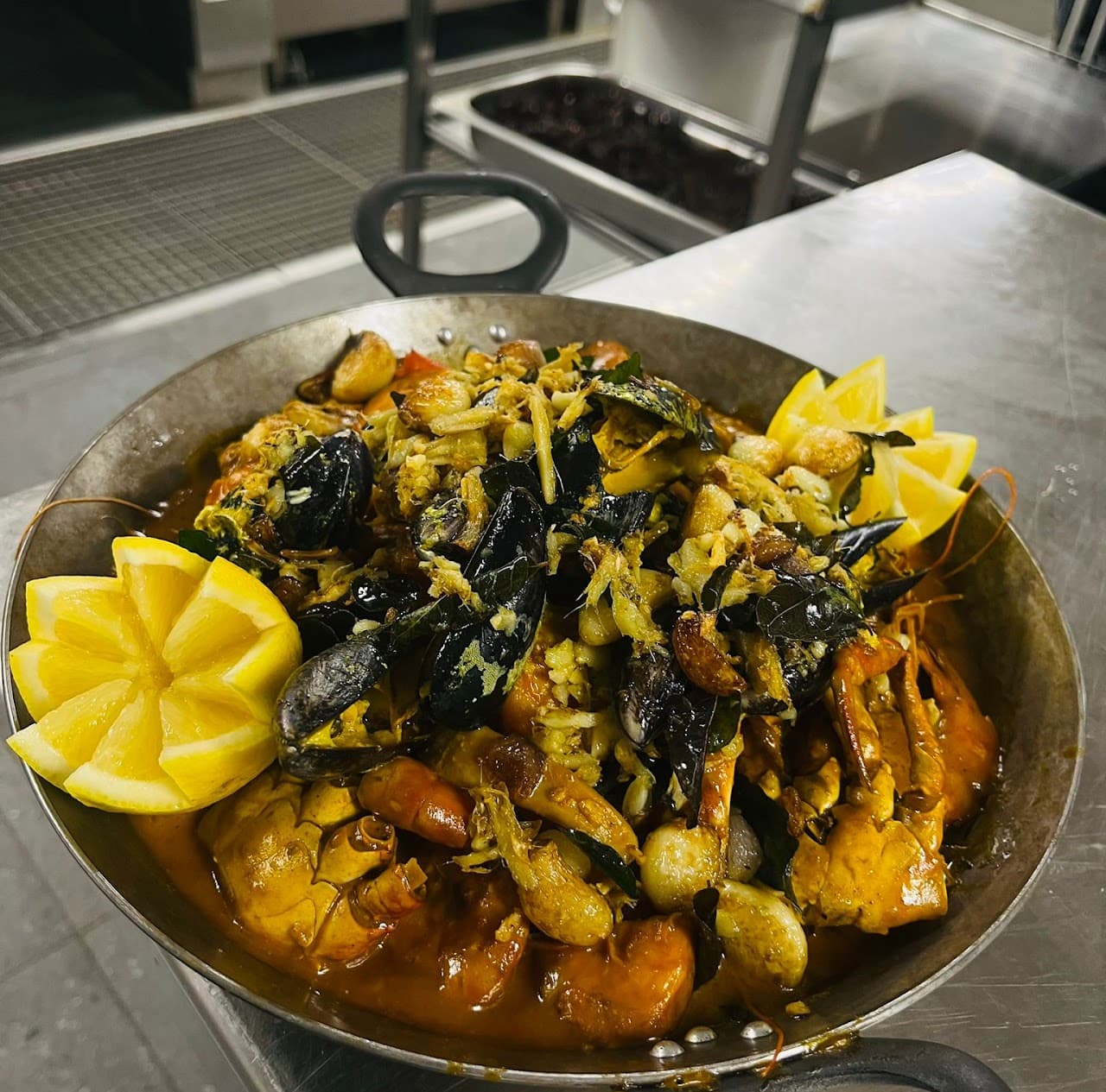 Meeresfrüchte-Curry mit Muscheln, Crevetten und Zitrone in Pfanne